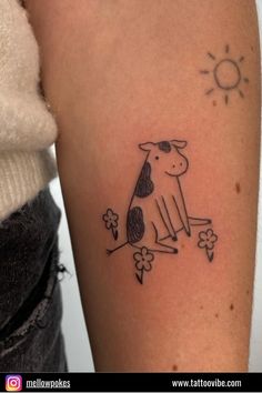 a small black and white tattoo of a cow sitting on a tree branch with flowers