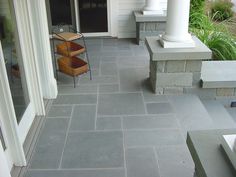 an outdoor patio with stone steps and chairs