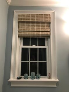 a window with some cups on the ledge