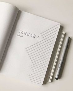 an open notebook with the word january written on it and a pen next to it