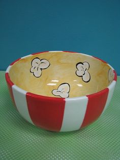 a red and white striped bowl with cartoon mouses on it sitting on a table