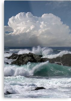 an ocean scene with waves crashing on rocks and clouds in the sky over them,