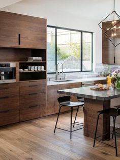 a modern kitchen with wooden cabinets and an island in front of the countertop area