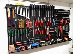 a wall mounted tool rack filled with lots of different tools and wrenches on it