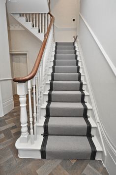 there is a gray and black carpeted stair case on the stairs in this house