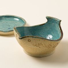 two ceramic bowls sitting next to each other