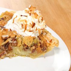 a slice of pie on a plate with whipped cream and pecans in the middle