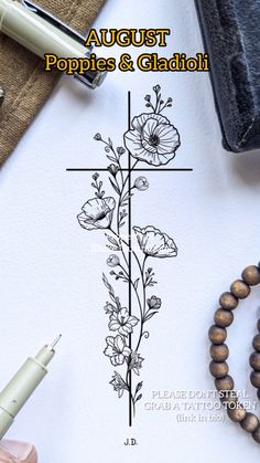 a cross with flowers on it next to a pen and some other items in front of it