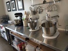 two mixers are sitting on top of a counter in a kitchen with utensils hanging from the wall