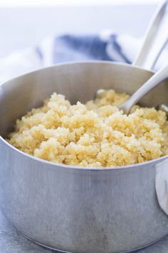 a pot filled with rice and two spoons in it