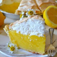 a slice of lemon pie on a white plate with daisies and forks next to it