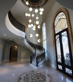 a spiral staircase with chandelier and glass windows