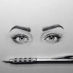 a pencil drawing of two eyes and a pen