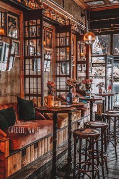 the interior of a restaurant with wooden tables and stools