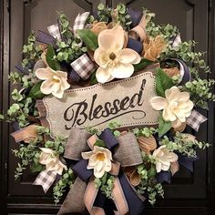 a wreath with flowers on it that says, blessed and is hanging from the front door