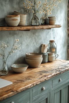 a kitchen counter with bowls and vases on it