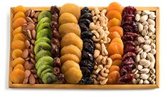 an assortment of dried fruits and nuts in a wooden tray