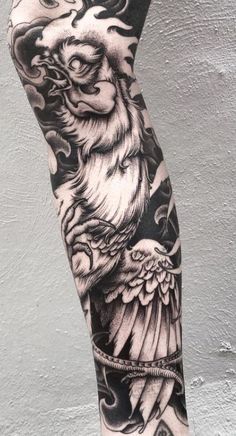 a man's leg with tattoos on it and an eagle in the middle of his arm