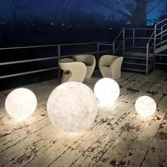 some chairs and lights on a wooden deck