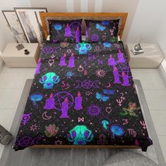 a bed with purple and blue designs on the cover is next to a night stand