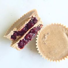 a peanut butter and jelly sandwich next to a cupcake on a white table top