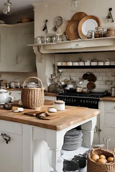 a kitchen filled with lots of white cabinets and wooden counter top next to an oven