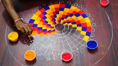 a person standing over a table with some paint on it and an object in the middle