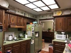 a kitchen filled with lots of wooden cabinets and green counter tops, along with a skylight