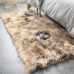 a furry rug on the floor next to a bed with high heel shoes laying on it