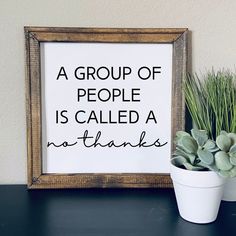 a group of people is called a no thanks sign next to a potted plant