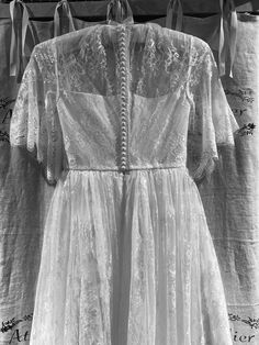 an old fashioned dress hanging on a clothes line with ribbons attached to the clothingline