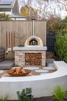 an outdoor fireplace with firewood in the middle