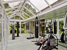 an indoor gym with exercise equipment and mirrors