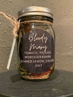 a jar filled with food sitting on top of a wooden table next to a wall