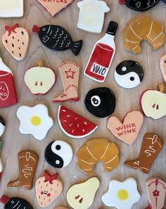 decorated cookies with different types of food on top of a wooden table next to each other