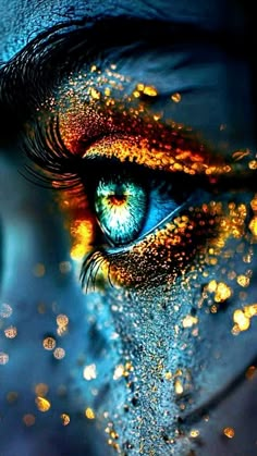 an eye with glitter all over it's face and blue eyes are shown in the image