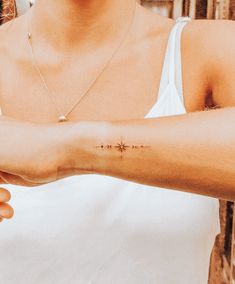 a woman with a cross tattoo on her arm