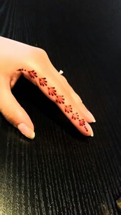 a woman's hand with red flowers painted on the left side of her arm