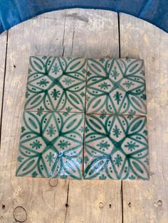 some green and white tiles sitting on top of a wooden table