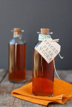 two bottles filled with liquid sitting on top of a wooden table