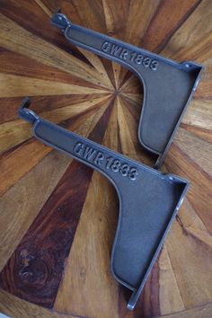 two black metal objects sitting on top of a wooden table