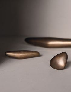 three shiny metal objects on a white surface