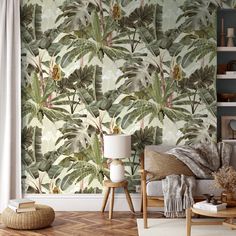 a living room with a couch, chair and wallpaper that has tropical leaves on it