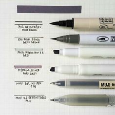 four different ink pens sitting next to each other on top of a sheet of paper