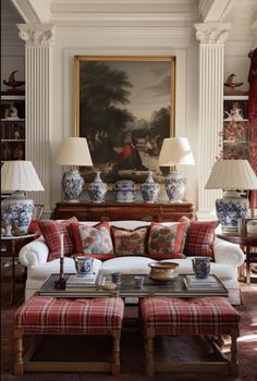 a living room filled with furniture and paintings on the wall next to two lamp shades