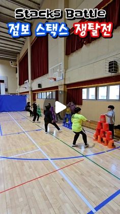 several people are playing basketball in an indoor court with blue and red lines on the floor