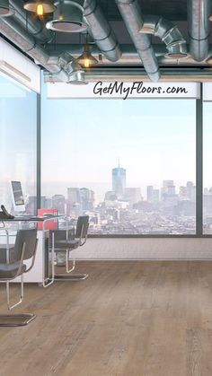 an office with wooden floors and large windows looking out on the cityscape in the distance