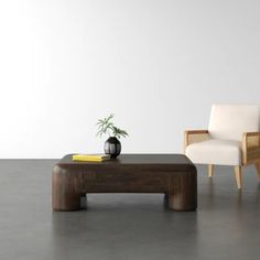 a living room with two chairs and a coffee table in front of a white wall