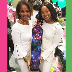 two women standing next to each other holding a skateboard