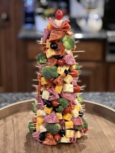 a christmas tree made out of fruits and veggies on a wooden platter